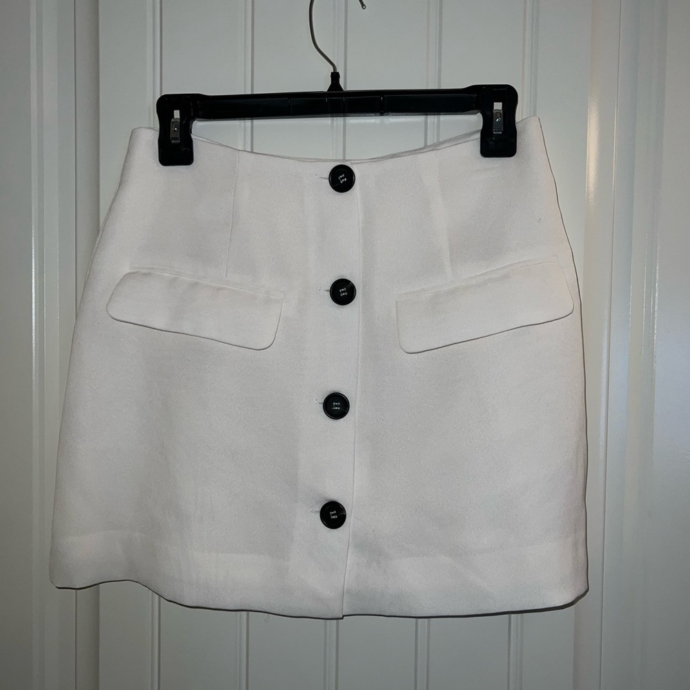 Creamy white mini skirt with black buttons